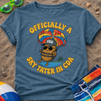 Blue t-shirt with a cartoon potato skydiving graphic and text on a sandy background.